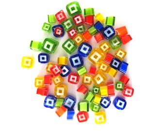 Puede incluir: Una colección de azulejos de vidrio coloridos con un diseño cuadrado blanco en el centro de cada azulejo. Los azulejos son en tonos de rojo, amarillo, verde y azul.