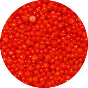 May include: Close-up of a circular arrangement of small, vibrant red spheres. The spheres vary slightly in size and have a glossy, reflective surface. The overall effect is a dense, textured pattern of bright red dots.