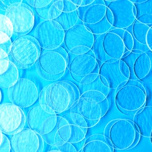 May include: An abstract image featuring numerous translucent, circular shapes overlapping on a vibrant blue background. The circles vary in size and transparency, creating a layered effect. The overall composition is a modern, artistic design.