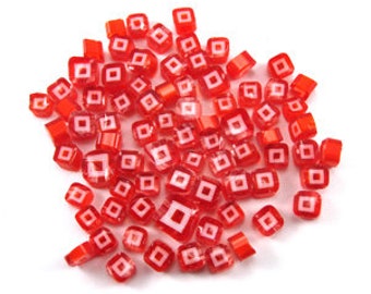Puede incluir: Una colección de cuentas cuadradas de vidrio rojo con un diseño cuadrado blanco en el centro. Las cuentas miden aproximadamente 1,2 cm.