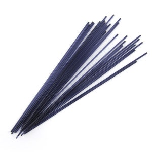May include: A bundle of thin, dark purple glass rods. The rods are approximately 12 inches long and are arranged in a fan shape.