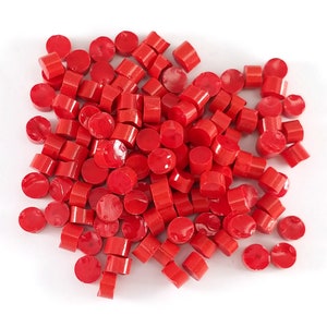 May include: A large pile of small, bright red, round plastic beads.