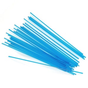 Puede incluir: Un conjunto de finas varillas rectas de plástico azul claro dispuestas en diagonal sobre un fondo blanco. Las varillas son de longitud y grosor uniformes, con una ligera translucidez.