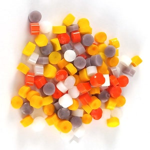 May include: A collection of small, round, colorful glass tiles in shades of yellow, orange, white, and purple. The tiles are arranged in a random pattern and are perfect for crafting projects.