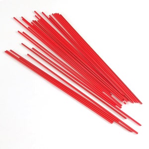 Könnte beinhalten: Ein Bündel roter Glasstäbe, etwa 30 cm lang, zum Glasblasen oder Basteln.