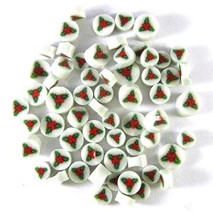 May include: A collection of white ceramic tiles with a red and green holly design. The tiles are round and have a glossy finish.