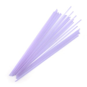 May include: A bundle of thin, translucent lavender-colored glass rods.