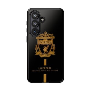 Op de afbeelding: Zwarte telefoonhoes met het logo van Liverpool Football Club in goud. Het ontwerp bevat het embleem van het team, de woorden "Liverpool Football Club" en de zin "You'll Never Walk Alone."