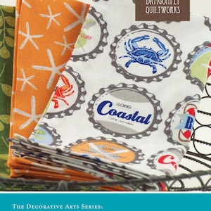 May include: A sewing pattern for mitered napkins with a coastal theme. The pattern features a stack of napkins with various designs including seashells, crabs, and the words "Going Coastal".