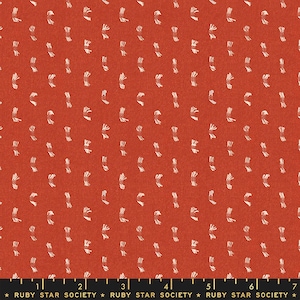 Puede incluir: Tela roja con un patrón blanco repetitivo de pequeños trazos de pincel estilizados. La tela tiene una superficie texturizada y está marcada con una regla en pulgadas. El texto "RUBY STAR SOCIETY" está impreso en la regla.