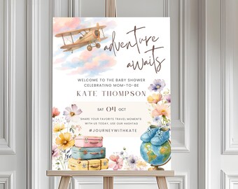 May include: A baby shower sign with the words "adventure awaits" and the name "Kate Thompson." It features a watercolor illustration of a biplane, suitcases, flowers, baby shoes, and a globe. The date is October 4th.