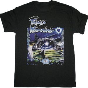 May include: Black t-shirt featuring the band name "Fates Warning" in white stylized text above a fantasy landscape graphic. The graphic includes a starry sky, archway, and the text "Awaken the Guardian".
