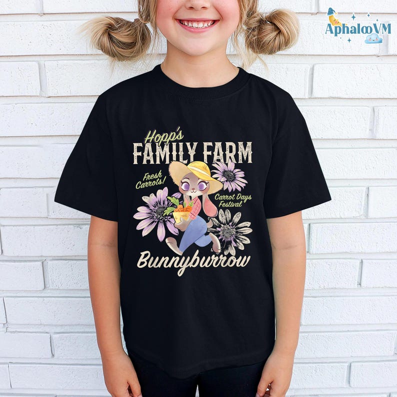 A young girl wearing a black t-shirt with a cartoon rabbit and text related to a farm.