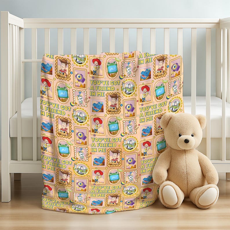 May include: A light orange blanket featuring a repeating pattern of Toy Story characters in rectangular and circular frames, including Woody, Buzz Lightyear, and Rex. The text "YOU'VE GOT A FRIEND IN ME" is printed in green throughout the design.