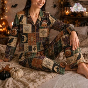 May include: A long-sleeved button-down pajama shirt and matching pants featuring a patchwork pattern of Halloween motifs including black crows, jack-o'-lanterns, crescent moons, and pine trees, with text reading Holiday Haunt and Creepmas Town.