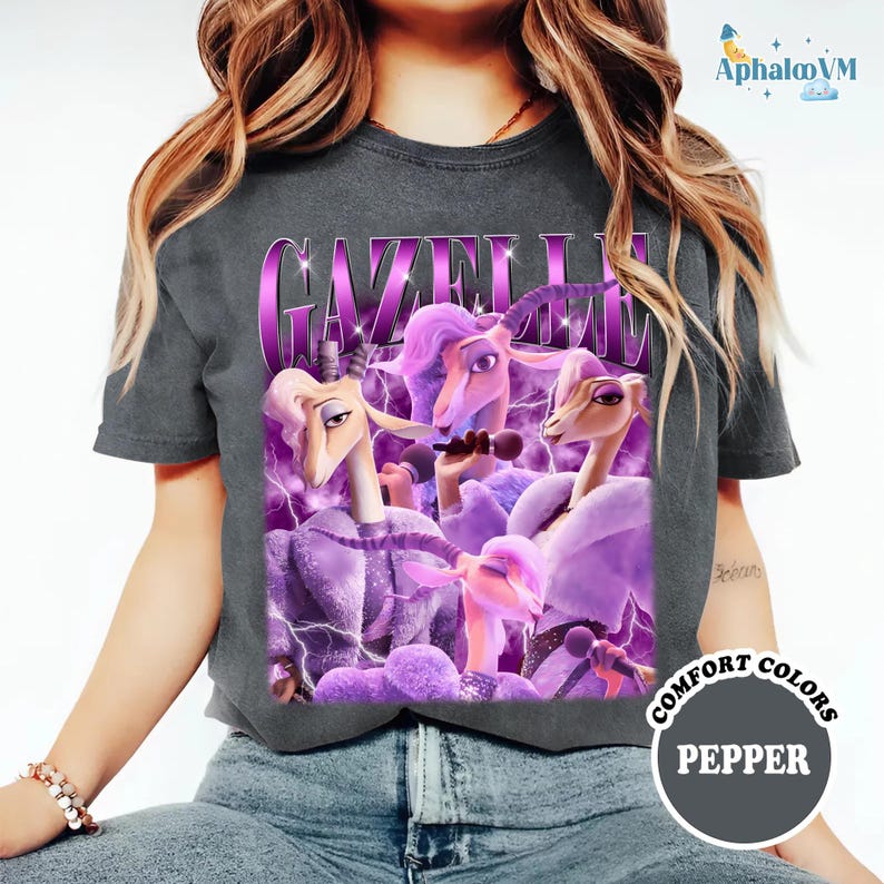 A person wearing a gray t-shirt with a graphic design featuring purple and pink cartoon animals, including a unicorn and a dragon.