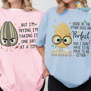two people wearing t-shirts with humorous text and cartoon characters.