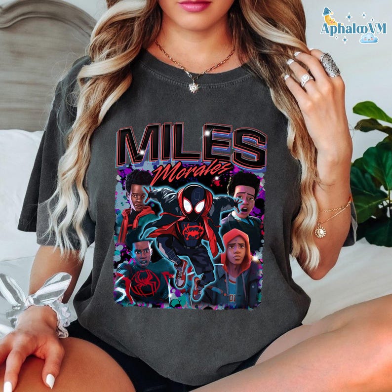A person wearing a gray t-shirt with a graphic design featuring characters from the Spider-Man movie franchise.