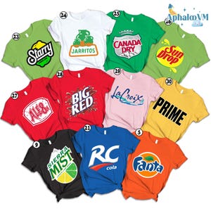 May include: A collection of colorful t-shirts, each featuring a different soda or beverage brand logo. The shirts are in various colors, including green, red, white, and orange. Logos include "Starry", "Jarritos", "Canada Dry", "Sun Drop", "Big Red", "La Croix", "Prime", "Sierra Mist", "RC Cola", and "Fanta".