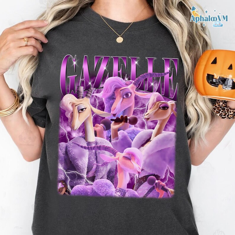 A person wearing a black t-shirt with a graphic design featuring purple and pink cartoon-style animals, including a unicorn and a dragon, along with the word "Gazelle" prominently displayed.