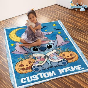 May include: A blue blanket featuring a cartoon character with a witch hat, pumpkins, and the text "CUSTOM NAME". The blanket has a light blue border and a design of stars, bats, and a crescent moon.