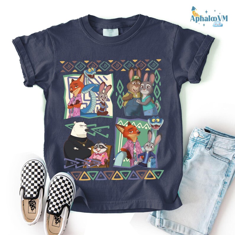 A t-shirt featuring a colorful graphic of cartoon animal characters, including a fox, rabbit, and other animals, along with a geometric pattern. The t-shirt is placed on a white background, and there are a pair of black and white checkered shoes and a pair of blue jeans visible in the image.