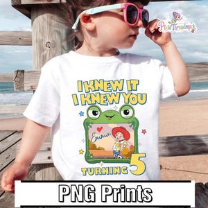 May include: A white t-shirt featuring a graphic of a green frog-shaped frame containing a cartoon character with red hair and a cowboy hat. The text reads I KNEW IT I KNEW YOU TURNING 5, with the name Emma written in cursive inside the frame.