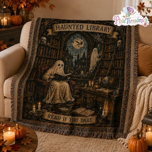 May include: A woven throw blanket featuring a dark, detailed illustration of a haunted library with ghosts, bookshelves, and a large window. The text HAUNTED LIBRARY appears at the top and READ IF YOU DARE is printed on a banner at the bottom.