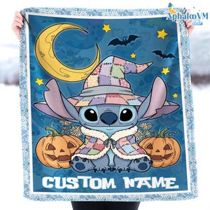 May include: A blue blanket featuring a cartoon character wearing a patchwork hat and cape, with two jack-o'-lanterns, a crescent moon, stars, and bats. The blanket has a white border and the text "CUSTOM NAME".