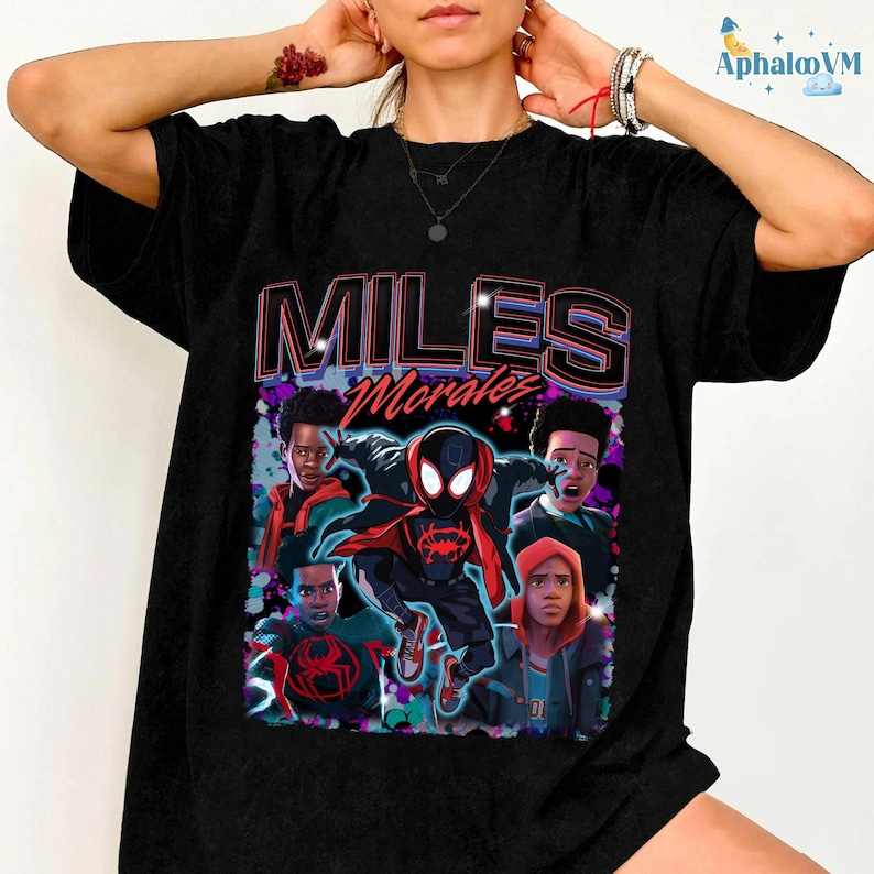 A person wearing a black t-shirt with a graphic design featuring characters from the Spider-Man movie franchise.