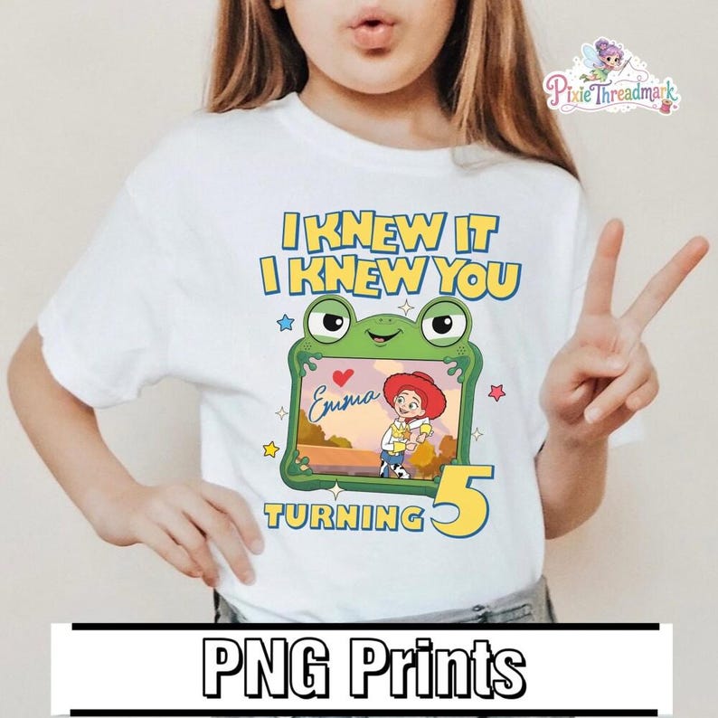May include: A white t-shirt featuring a graphic of a green frog character holding a picture frame that contains an illustration of a cowgirl character and the name Emma. The text reads I KNEW IT I KNEW YOU TURNING 5 with a large yellow number 5.