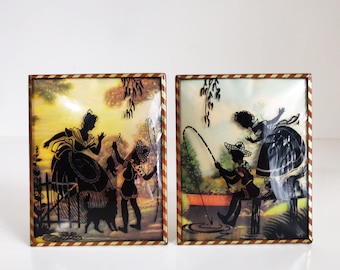 Pair of Benton Reverse Painted Silhouette Wall Hangings with boys fishing, victorian girls and dogs