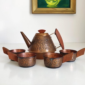 Miedziany czajniczek i filiżanki Bauhaus z drewnianymi akcentami