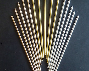 May include: A set of 15 gold and silver metal rods arranged in a fan shape on a black background.