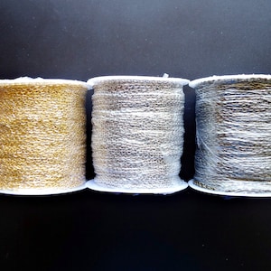 May include: Three spools of metallic chain, one gold, one silver, and one black, wrapped in clear plastic.