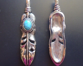May include: Two silver-toned feather pendants. One pendant features an oval turquoise stone at the top, with intricate feather detailing. The other pendant is a hollowed-out version of the same feather design. Both have a loop at the top for a chain.
