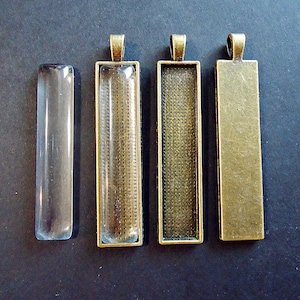 May include: Three rectangular glass pendant trays with a bronze metal frame. The trays are empty and ready for crafting.