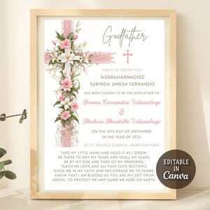 May include: A framed print with a light wood frame. The print features a pink cross adorned with flowers and text that reads "Godfather." The names of the individuals and the date are also included. The words "Editable in Canva" are in the bottom right corner.