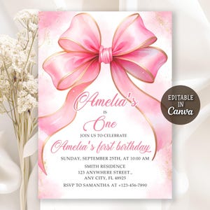 Puede incluir: Invitación de cumpleaños rosa y dorada con un gran lazo de acuarela. La invitación dice "Amelia's is One" e incluye los detalles de la fiesta. El diseño es editable en Canva.
