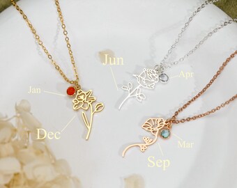 Könnte beinhalten: Drei zarte Halsketten mit dünnen Metallketten und Blumenanhängern. Eine goldene Kette mit rotem Stein und Jan-Beschriftung, eine silberne Kette mit klarem Stein und Jun/Apr-Beschriftung sowie eine roségoldene Kette mit blauem Stein und Dec/Mar/Sep-Beschriftung.