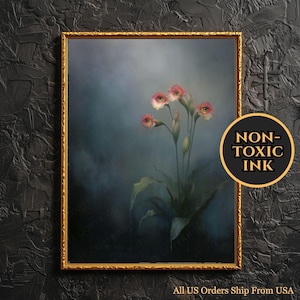 May include: A framed art print featuring a surreal floral arrangement with pink and white blooms. The artwork is set against a dark, moody background. A gold frame surrounds the print. The image includes a circular "NON-TOXIC INK" label.