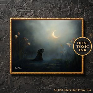 May include: A framed painting shows a black dog in water, looking up at a crescent moon in a night sky. The artwork has a gold frame, with the word "bella" and a "NON-TOXIC INK" sticker. The scene is set in a tranquil, moonlit environment.