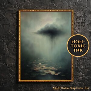 Może przedstawiać: Oprawiony wydruk artystyczny przedstawiający spokojny krajobraz z ciemną chmurą uwalniającą deszcz nad stawem wypełnionym liliami wodnymi i kwiatami. Grafika jest w złotej ramie i zawiera tekst "NON-TOXIC INK".