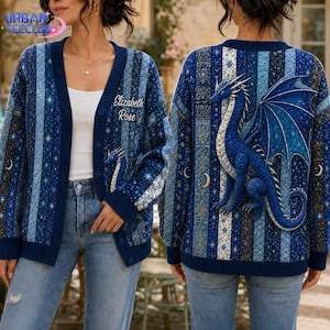 May include: A blue button-up cardigan featuring a vertical striped pattern with celestial motifs and a large blue dragon graphic on the back. The front left chest displays the embroidered text Elizabeth Rose, and the garment is worn over a white top.