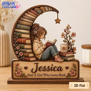 May include: A decorative wooden tabletop sign featuring a crescent moon made of stacked books, a girl reading a book, a mug, and floral accents. The base is engraved with the name Jessica and the text Just A Girl Who Loves Book.