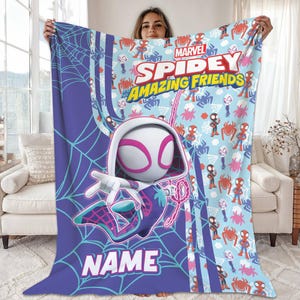May include: A Marvel Spidey and His Amazing Friends blanket featuring a large graphic of Spider-Gwen in a dynamic pose. The blanket has a light blue background with repeating Spidey characters and spiderwebs. The blanket is purple and blue with the text "NAME" at the bottom.