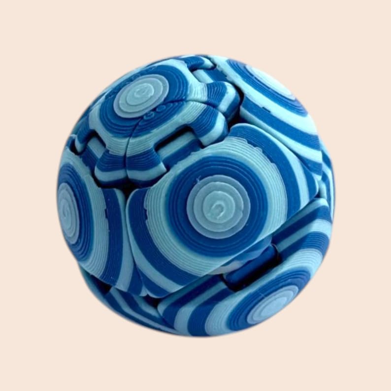 Pu&ograve; includere: Una palla puzzle blu e bianca con un design a cerchi concentrici. La palla &egrave; composta da pezzi ad incastro, creando una forma sferica. La combinazione di colori include sfumature di blu chiaro e scuro.