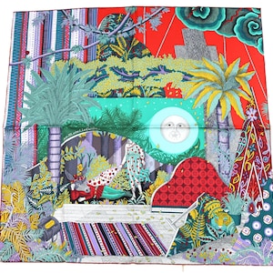 Può includere: Foulard quadrato in seta con un design vibrante e multicolore. La sciarpa presenta una scena centrale con figure, una luna e un fogliame lussureggiante, incorniciata da bordi a motivi rossi, verdi e blu. Il design della sciarpa include palme, uno sfondo rosso e testo.