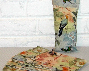 Könnte beinhalten: Ein Stapel von 12 bunten Umschlägen mit einem floralen und Vogel-Design. Die Umschläge sind gefaltet und übereinander gestapelt. Der oberste Umschlag hat ein Vogel- und Schmetterlings-Design. Die Umschläge sind aus Papier und haben eine glänzende Oberfläche.