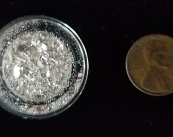 Silver scrap bits in plastic capsule